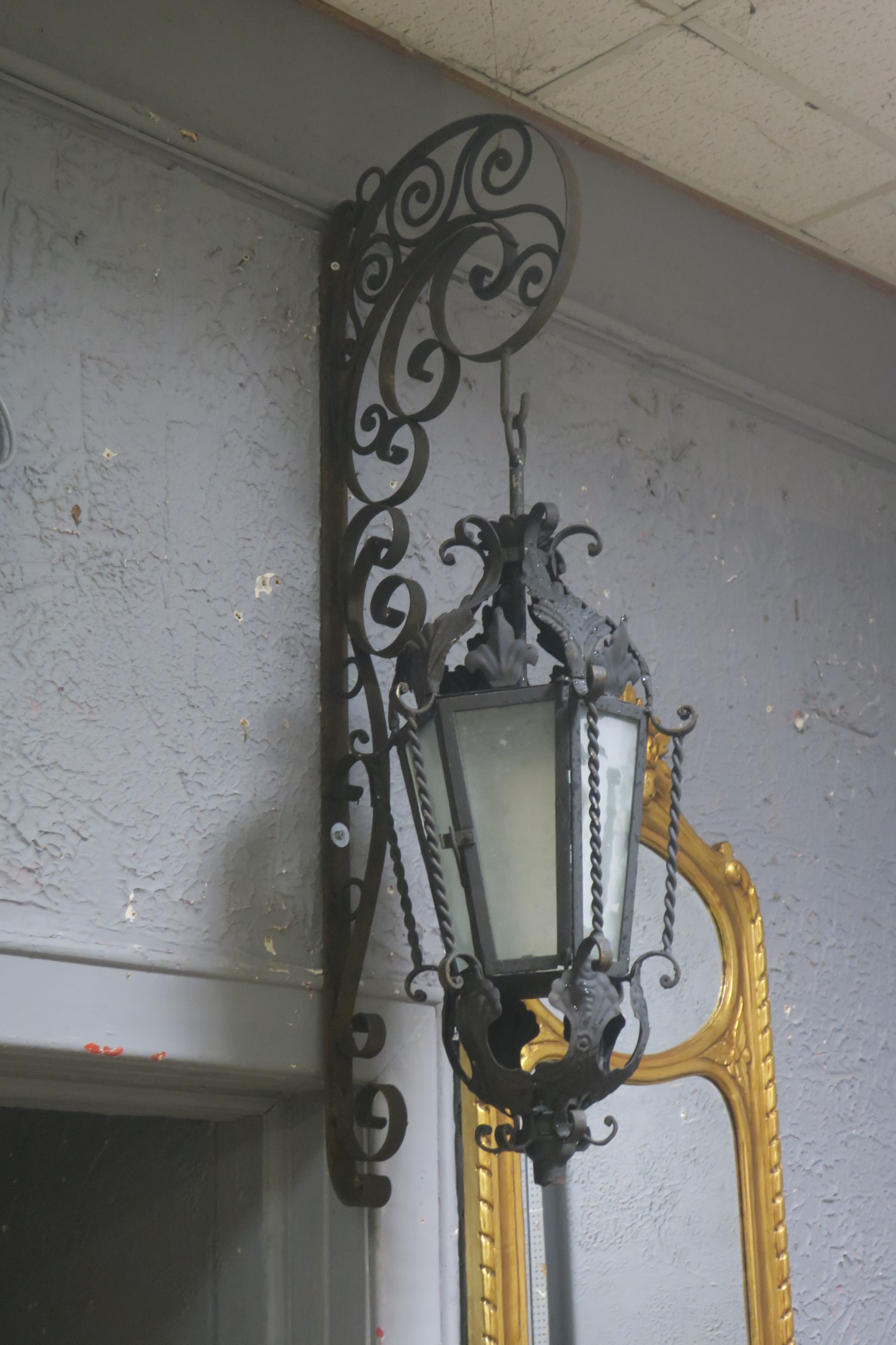A PAIR OF WROUGHT IRON WALL MOUNTED LANTERNS,