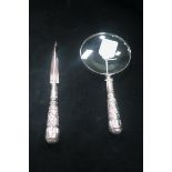 A SILVER PLATED EMBOSSED HANDLE MAGNIFYING GLASS,