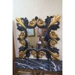 A CONTINENTAL EBONISED AND PARCEL GILT MIRROR,