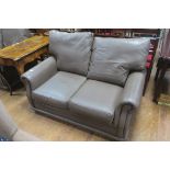 A CONTEMPORARY TWO SEATER HIDE UPHOLSTERED SETTEE,