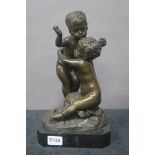 A BRONZE GROUP MODELLED AS CHILDREN EMBRACING shown seated on a rock work base raised on a marble