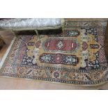 A WOOL RUG, the light brown ground with central panel filled with stylised flowerheads, foliage,