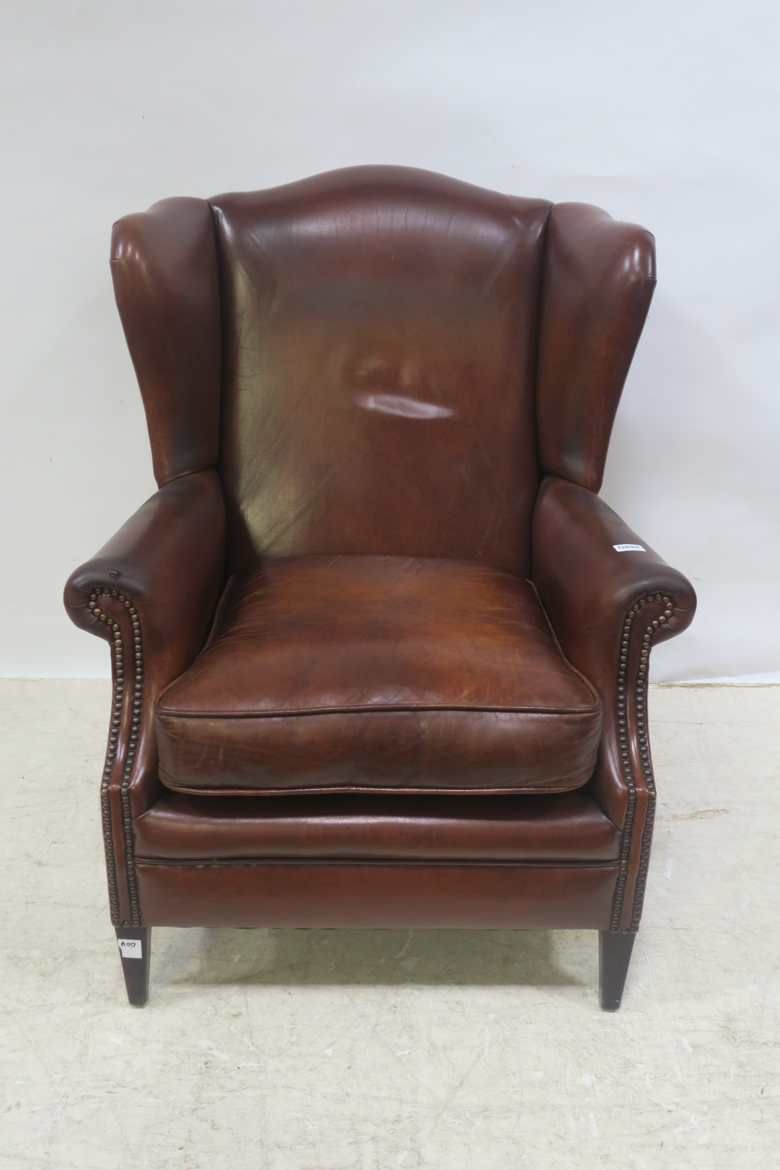 A HIDE UPHOLSTERED WING CHAIR,