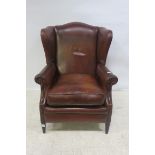A HIDE UPHOLSTERED WING CHAIR,