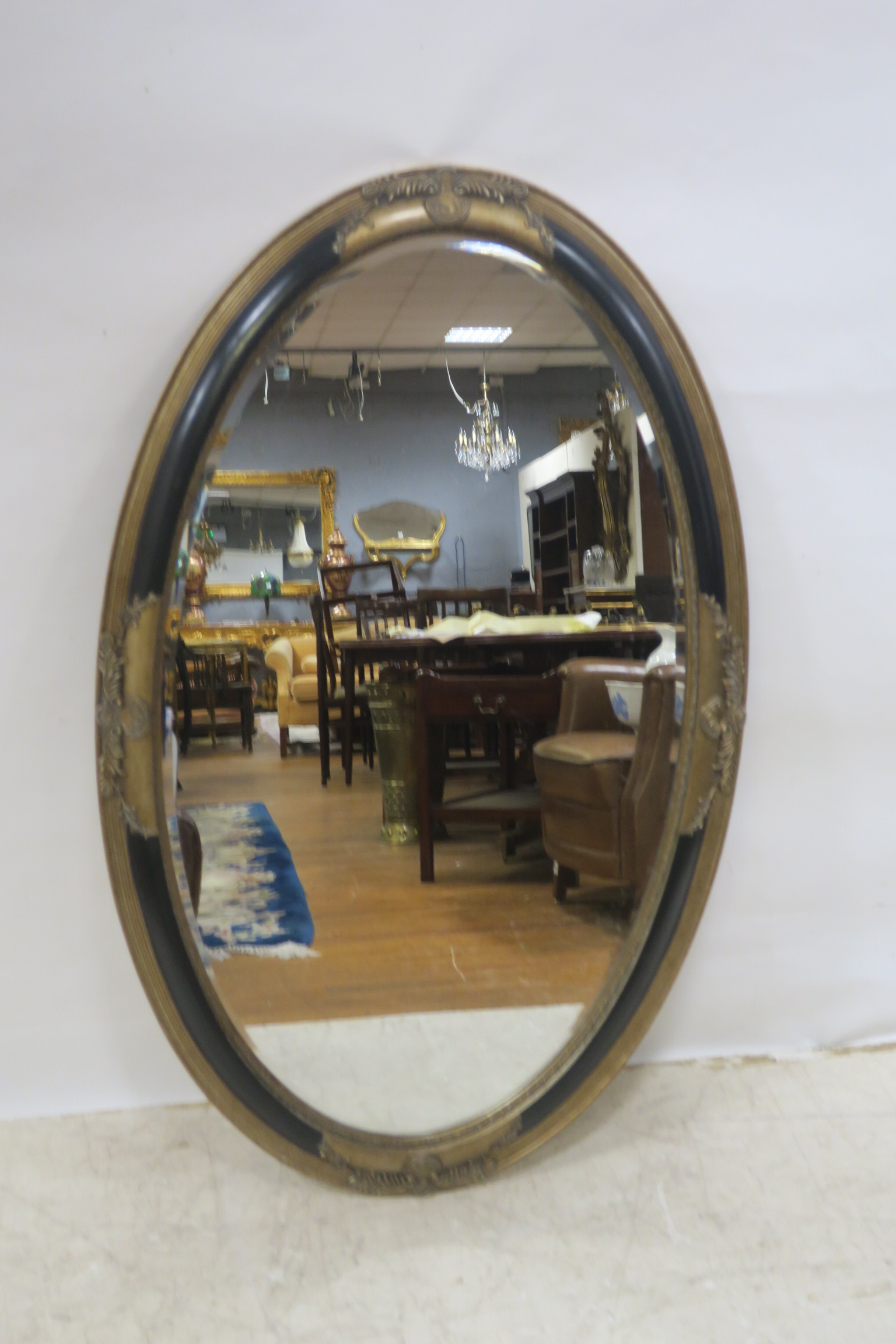 A GILT AND EBONISED MIRROR,