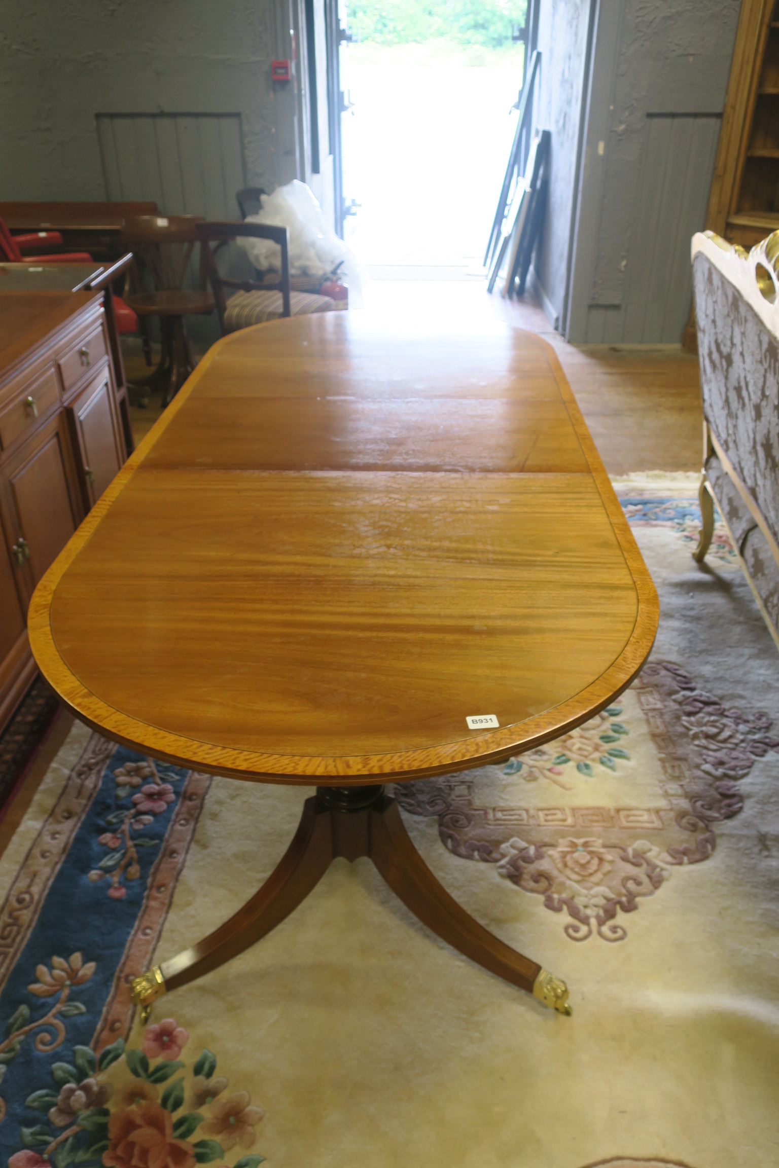 A REGENCY DESIGN MAHOGANY AND SATINWOOD CROSS BANDED DINING TABLE,