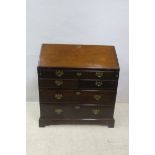 A GEORGIAN MAHOGANY BUREAU, the hinged writing slope containing pigeon holes,