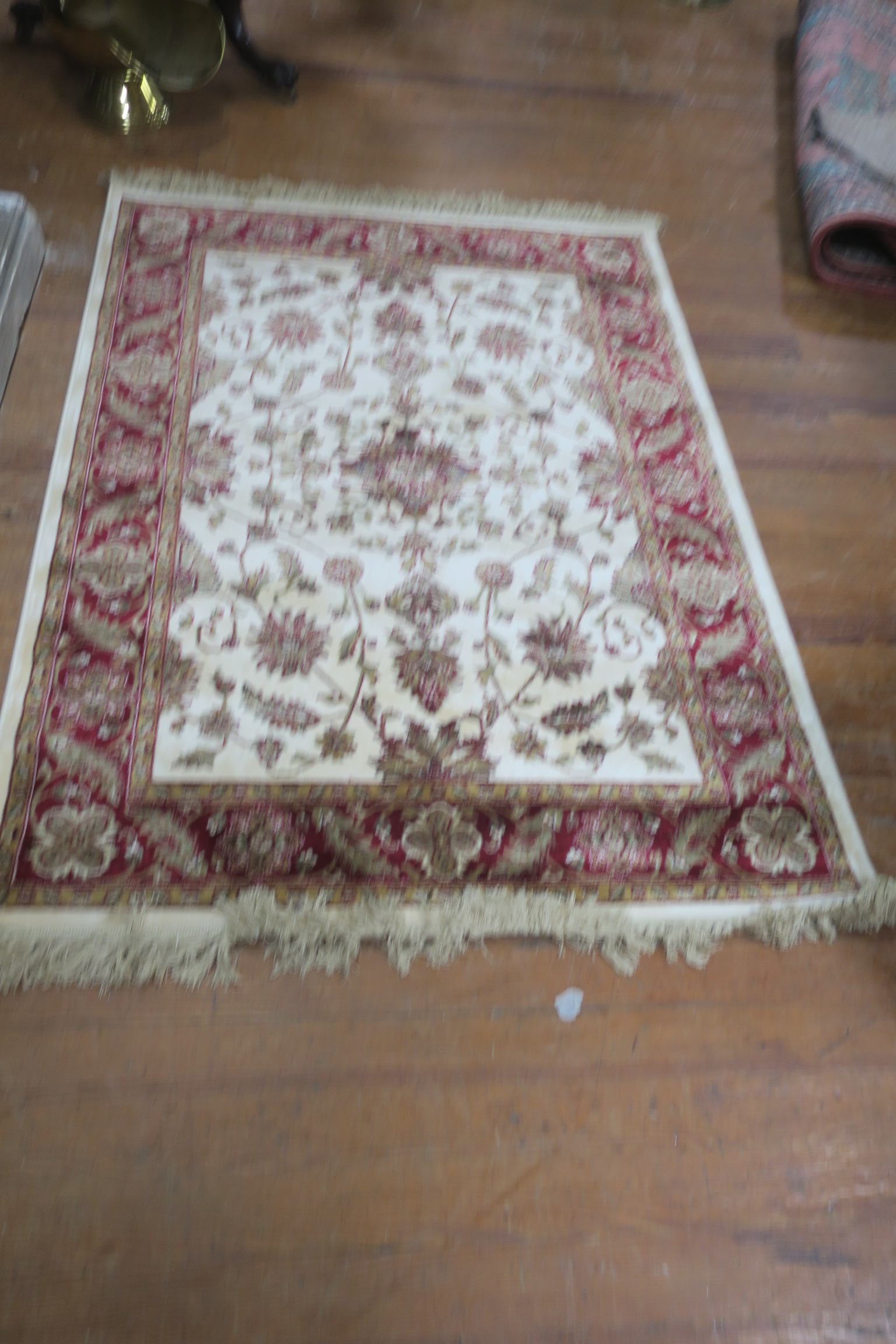 A BEIGE AND WINE GROUND PATTERN RUG,