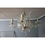 A GILT BRASS AND CUT GLASS FIVE BRANCH CHANDELIER,