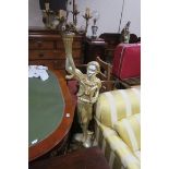 A NUBIEN GILTWOOD AND SILVERED FIGURE modelled as a young boy shown standing holding a five branch