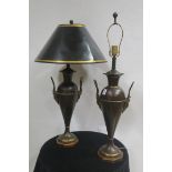 A PAIR OF BRONZED AND GILT BRASS TABLE LAMPS each of urn form with mask and scroll handles raised