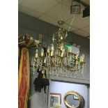 A CONTINENTAL GILT METAL AND CUT GLASS EIGHTEEN BRANCH CHANDELIER IN TWO REGISTERS hung with facet