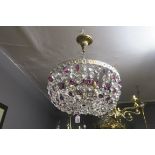 A CONTINENTAL GILT BRASS BASKET CENTRE LIGHT hung with ruby glass and clear glass facet pendants