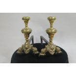 A PAIR OF 19TH CENTURY CAST BRASS AND STEEL FIRE DOGS each with a knopped finial above a figural