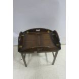 A MAHOGANY BUTLER'S TRAY AND STAND of oval outline with hinged sides raised on a moulded stand 67cm