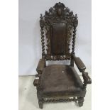 A 19TH CENTURY CARVED OAK ARMCHAIR with armorial cresting above a hide upholstered panel between