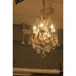 A CONTINENTAL GILT BRASS AND CUT GLASS SIX BRANCH CHANDELIER hung with pendant drops