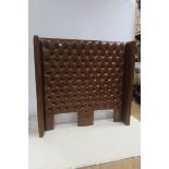 A RETRO BROWN HIDE UPHOLSTERED BUTTONED HEADBOARD with brass studding 170cm (w) 160cm (h)
