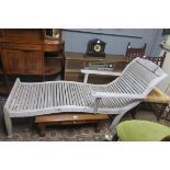 A HARDWOOD SUN LOUNGER with curved back and slatted seat with moulded arms