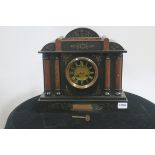 A 19TH CENTURY BLACK SLATE MANTLE CLOCK of architectural outline the circular dial with Roman