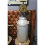 A MILK CHURN together with a brass and cast iron scales