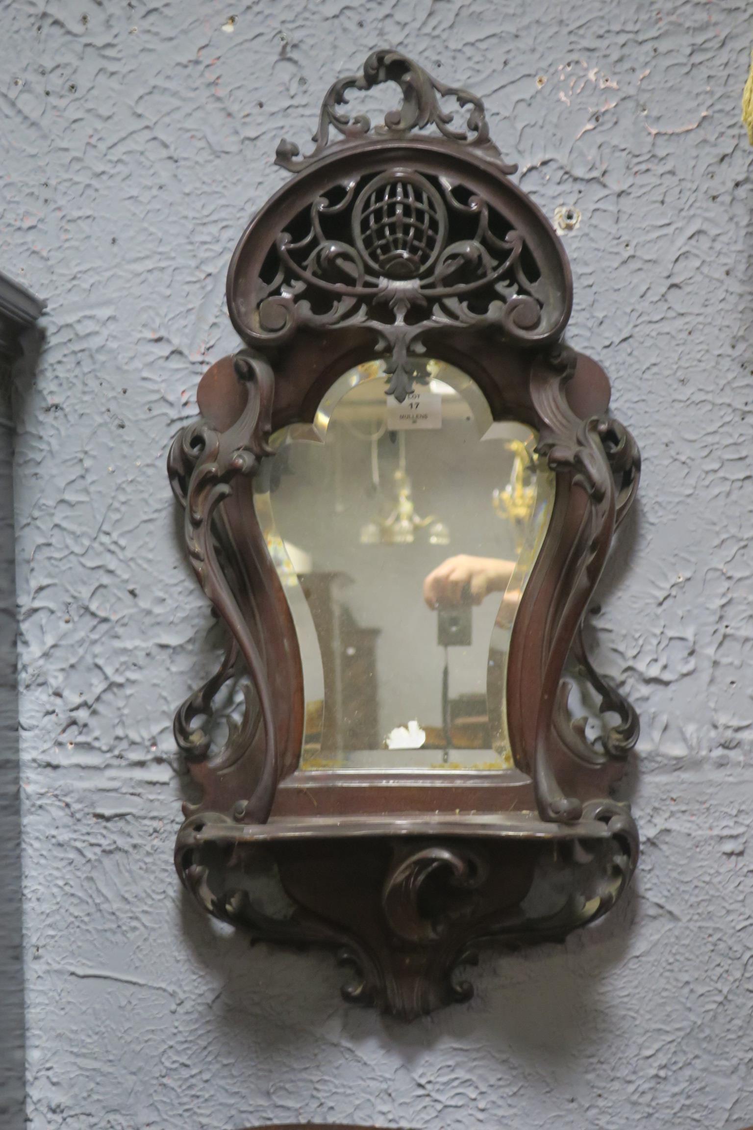 A PAIR OF 19TH CENTURY MAHOGANY MIRRORS each with a bevelled glass shaped plate with pierce carved