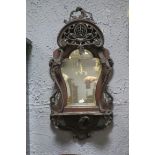 A PAIR OF 19TH CENTURY MAHOGANY MIRRORS each with a bevelled glass shaped plate with pierce carved