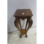 A CARVED MAHOGANY JARDINIERE STAND the serpentine top above a shaped frieze on cabriole legs with