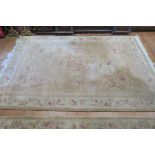A CHINESE WOOL RUG beige and cream ground with central floral panel with a conforming boarder 360cm