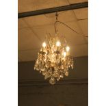 A CONTINENTAL GILT BRASS AND CUT GLASS SIX BRANCH CHANDELIER hung with pendant drops THE BUYER OF