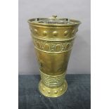 A 19TH CENTURY BRASS EMBOSSED FOUR COMPARTMENT STICK STAND of cylindrical tapering form with