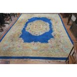 A CHINESE WOOL RUG the royal blue multicoloured ground with central floral panel with a conforming