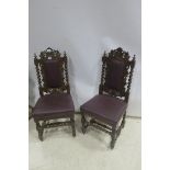 A SET OF TWELVE CARVED OAK DINING CHAIRS each with a armorial cresting above an upholstered panel