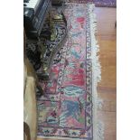 AN INDIAN WOOL RUG indigo and light pink ground with central floral panel with a conforming border