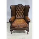 A FINE HIDE UPHOLSTERED WING BACK LIBRARY CHAIR with deep buttoned upholstered back and loose