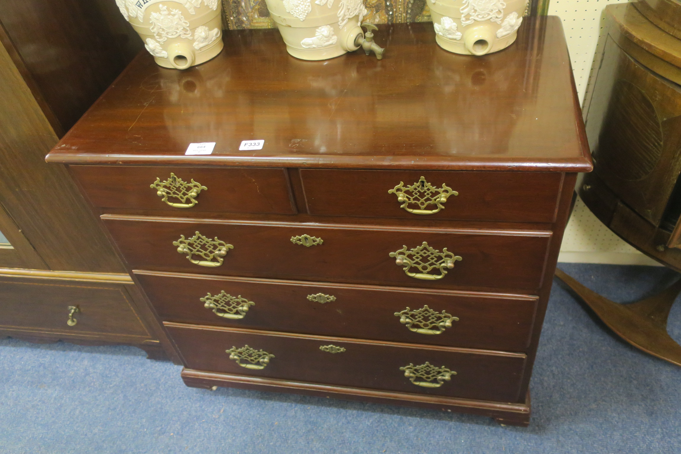 A GEORGIAN MAHOGANY CHEST of rectangular outline the shaped top above two short and three long