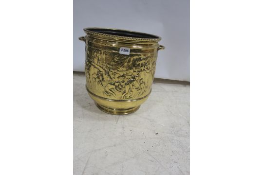 A BRASS EMBOSSED JARDINIERE of cylindrical outline with carrying handles raised in a circular