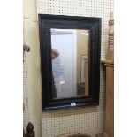 AN EBONISED FRAMED MIRROR,