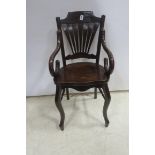 A BENTWOOD ELBOW CHAIR with pierced fan back with panelled seat scroll arms on cabriole legs joined