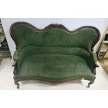 A CONTINENTAL MAHOGANY SETTEE the serpentine and carved top rail above an upholstered back and seat