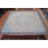 A WOOL RUG the cream and blue ground with central circular panel decorated with c-scroll