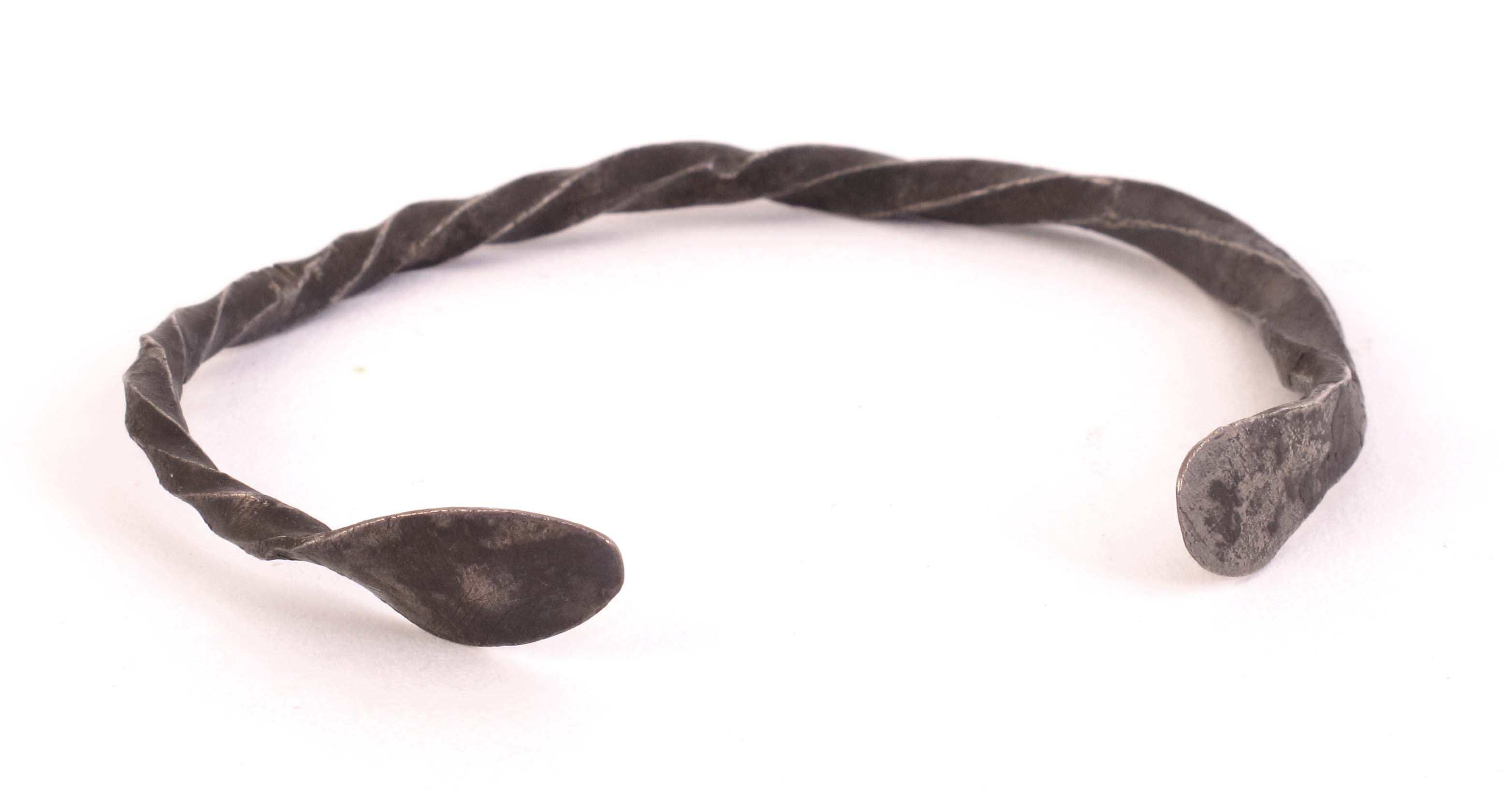 8th-9th century. Hiberno-Norse silver bracelet. The barley-twist band with spoon-shaped terminals.