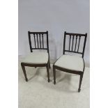 A SET OF FOUR HEPPLEWHITE DESIGN MAHOGANY DINING CHAIRS each with a shaped top rail and vertical