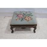 A 19TH CENTURY ROSEWOOD FOOTSTOOL the rectangular needle work upholstered seat above a carved apron