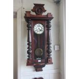 A 19TH CENTURY MAHOGANY CASE VIENNA CLOCK with figural mask cresting above the rectangular arched