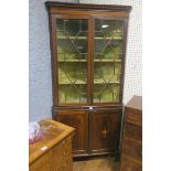 A GEORGIAN MAHOGANY AND SATINWOOD INLAID CORNER CABINET the outswept moulded cornice above a pair