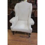 A 19TH CENTURY MAHOGANY AND UPHOLSTERED WING CHAIR with scroll over arms on carved legs