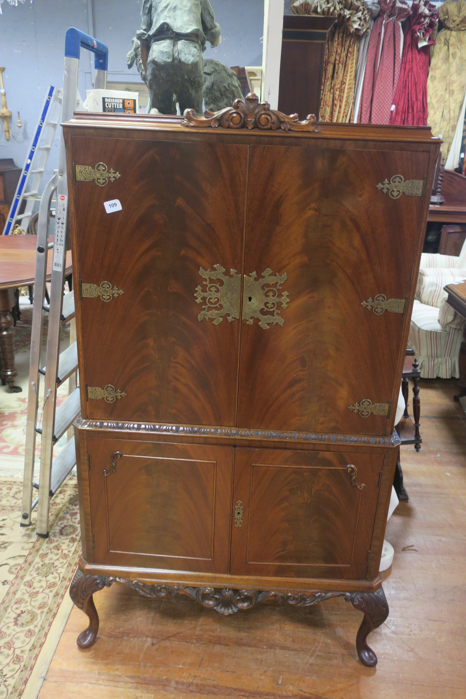 A CHIPPENDALE DESIGN MAHOGANY COCKTAIL CABINET the cavetto cornice with foliate carving above a