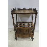 A 19TH CENTURY WALNUT CANTERBURY of serpentine outline the shaped top with pierced gallery and