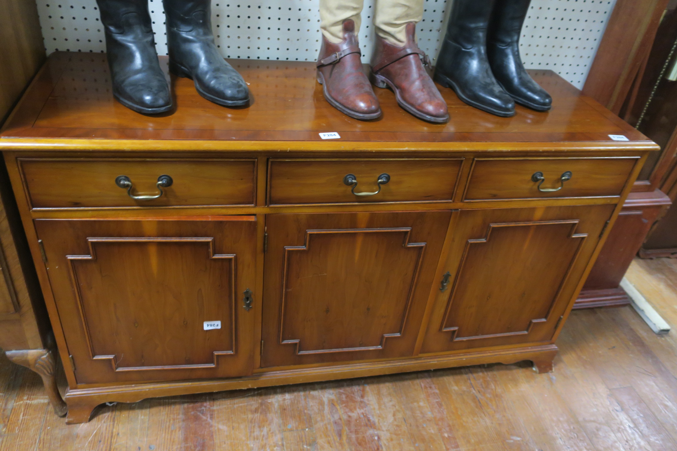 A YEW WOOD SIDE CABINET of rectangular outline the shaped top above two frieze drawers and